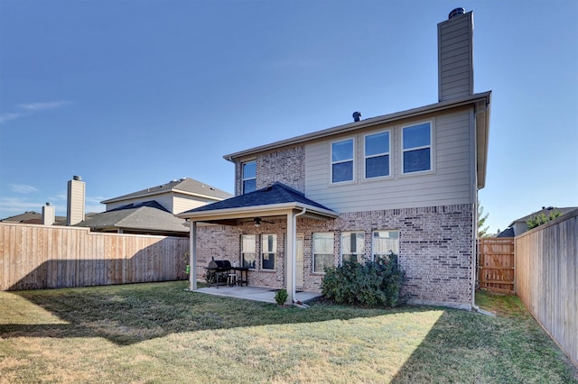 back of house with a patio area, a yard, and ceiling fan