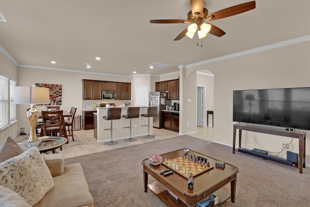 carpeted living room featuring ceiling fan and crown molding