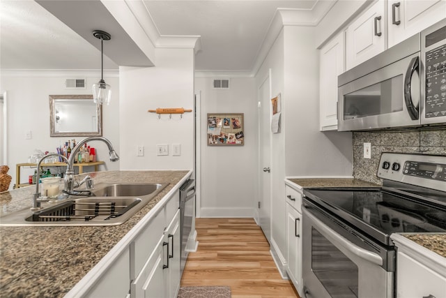 kitchen with ornamental molding, sink, white cabinetry, appliances with stainless steel finishes, and light hardwood / wood-style floors