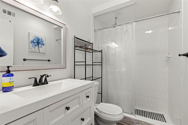 bathroom with toilet, hardwood / wood-style floors, a shower with curtain, and vanity