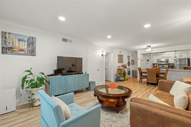 living room featuring light hardwood / wood-style floors and crown molding