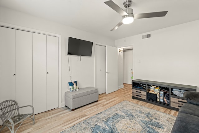 living room with ceiling fan and light hardwood / wood-style flooring