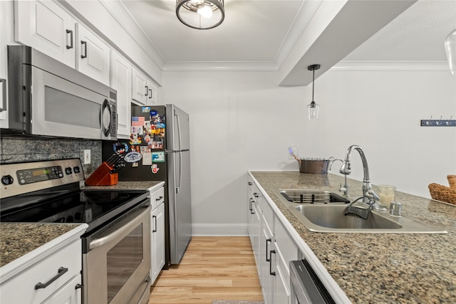 kitchen featuring appliances with stainless steel finishes, sink, light wood-type flooring, pendant lighting, and white cabinets