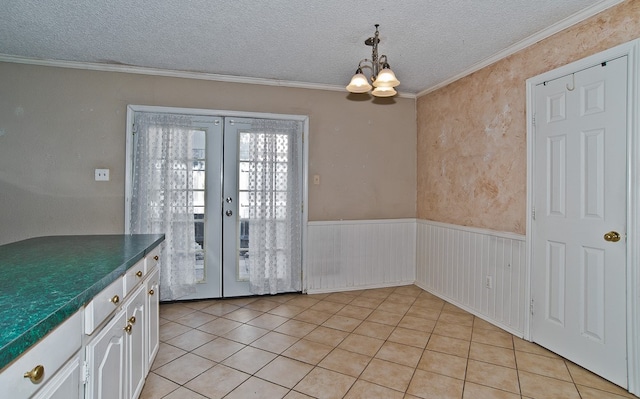 doorway to outside with light tile patterned flooring, french doors, a chandelier, and crown molding