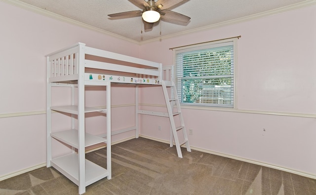 unfurnished bedroom with ornamental molding, carpet floors, a textured ceiling, and ceiling fan