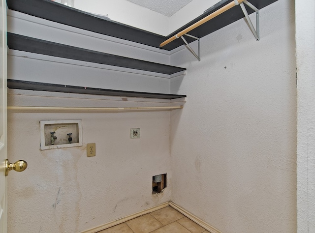 washroom featuring hookup for a washing machine, electric dryer hookup, a textured ceiling, and tile patterned flooring