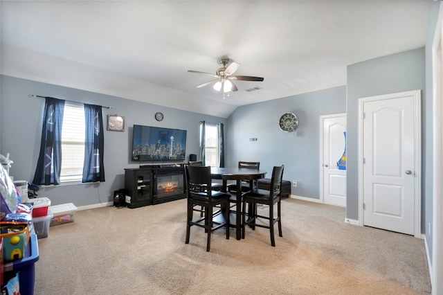 dining area featuring light carpet, lofted ceiling, and ceiling fan