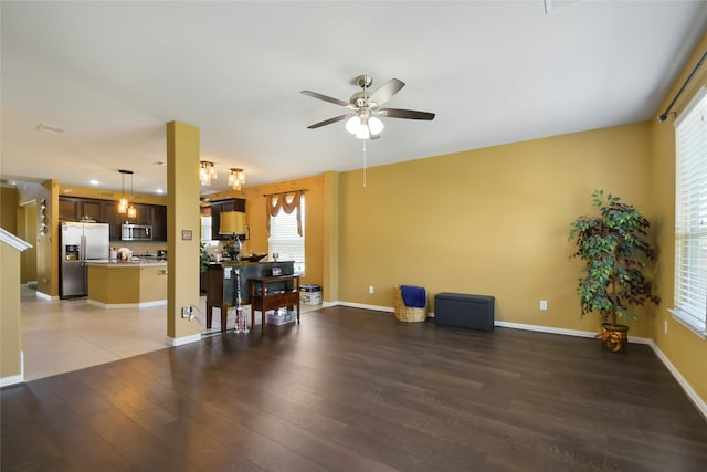 living room with a wealth of natural light, dark hardwood / wood-style floors, and ceiling fan