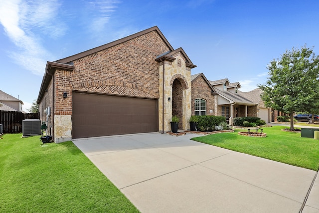 view of front of property featuring a front yard, central AC, and a garage