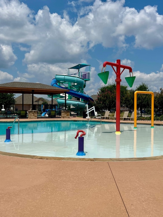 view of pool featuring a water slide and a patio