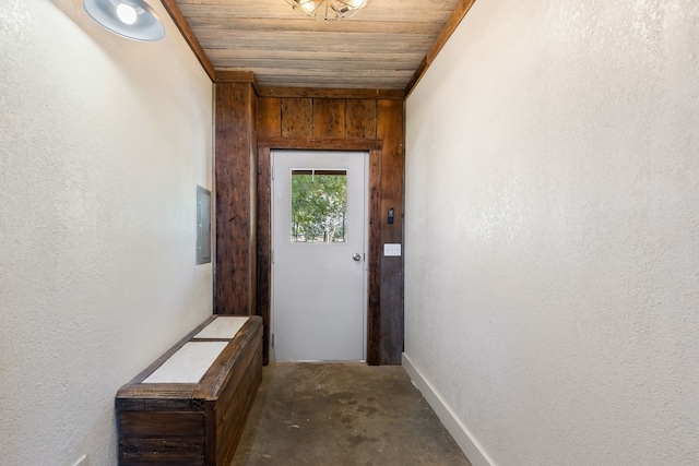 entryway featuring concrete floors, wood walls, wood ceiling, and crown molding