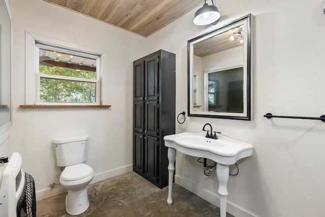 bathroom featuring toilet, heating unit, wood ceiling, and concrete flooring