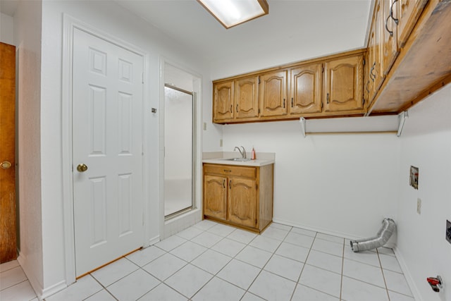 laundry area with cabinets, washer hookup, electric dryer hookup, sink, and light tile patterned flooring