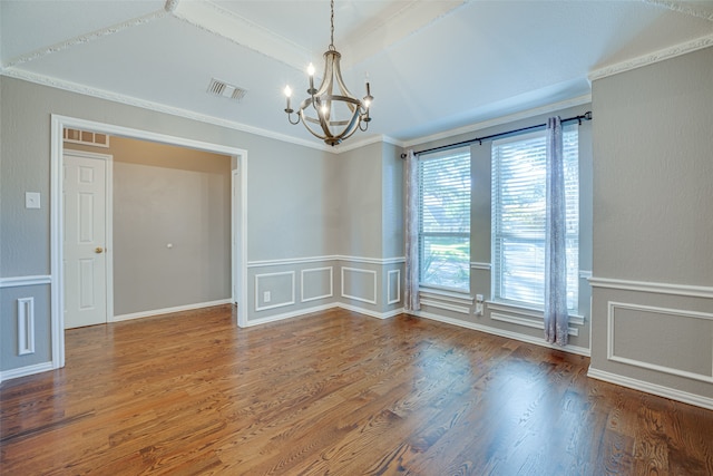 spare room featuring crown molding, an inviting chandelier, and hardwood / wood-style flooring