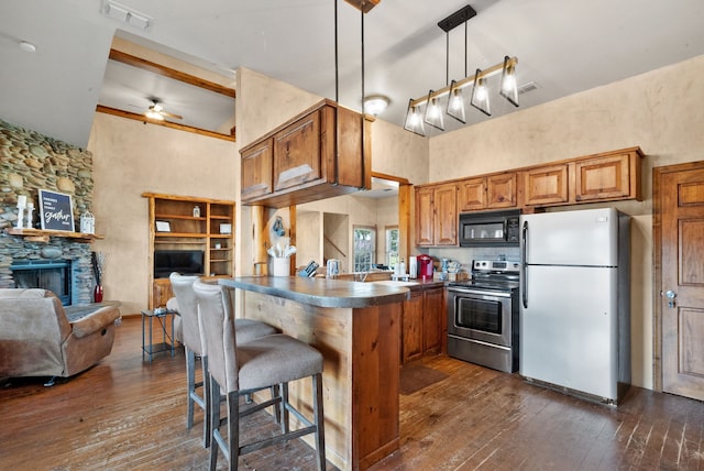 kitchen featuring stainless steel range with electric cooktop, kitchen peninsula, white fridge, dark wood-type flooring, and a breakfast bar area