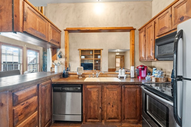 kitchen with sink, appliances with stainless steel finishes, and kitchen peninsula