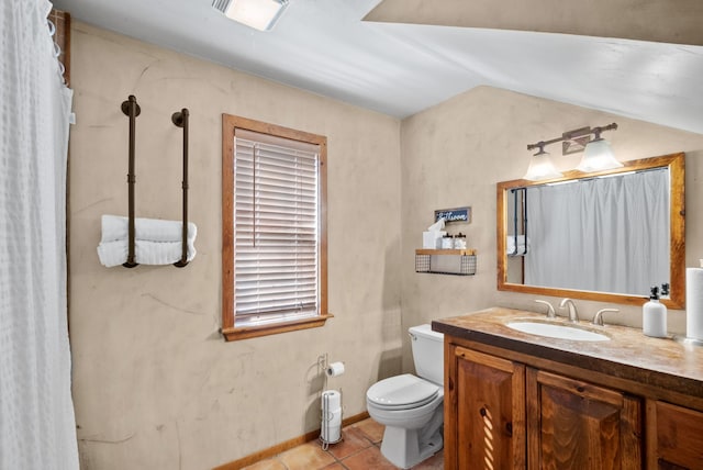 bathroom with vanity, lofted ceiling, toilet, and tile patterned floors