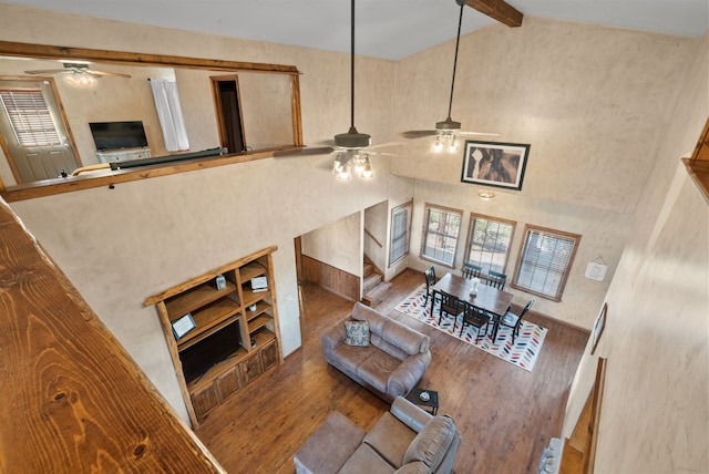 living room featuring beam ceiling, high vaulted ceiling, and wood-type flooring