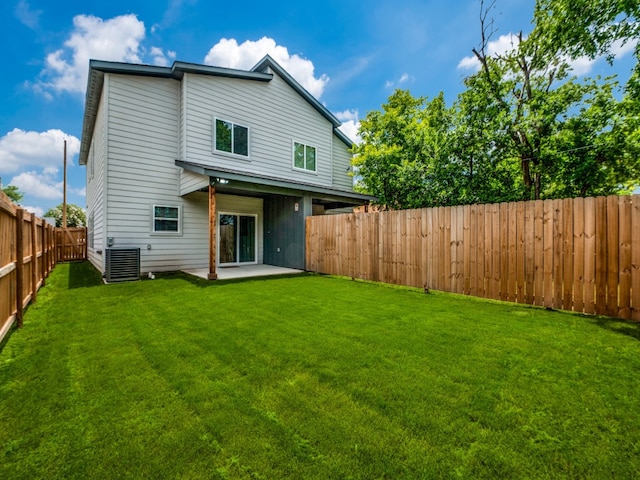 rear view of property with central air condition unit, a patio area, and a lawn