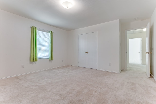 unfurnished bedroom featuring a closet and light carpet