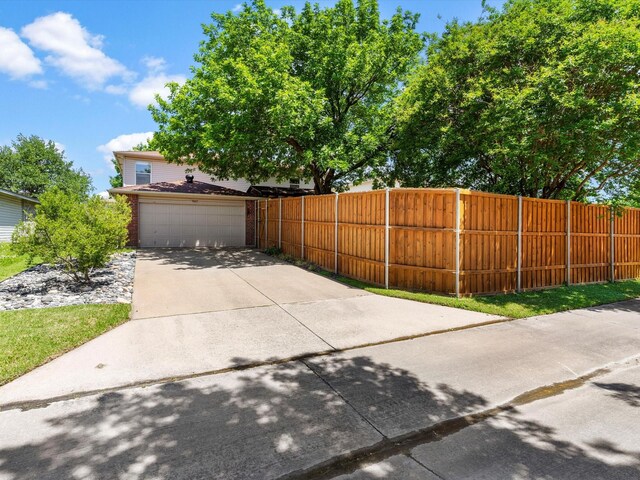 1517 Windward Ln, Wylie, TX 75098 - view of home's exterior featuring driveway, fence, a garage, and brick siding
