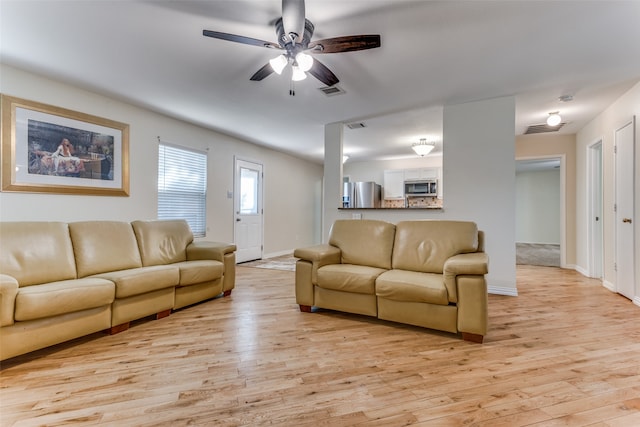 living room with ceiling fan and light hardwood / wood-style flooring