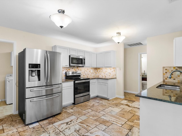 1517 Windward Ln, Wylie, TX 75098 - kitchen with stainless steel appliances, a sink, washer / clothes dryer, and decorative backsplash