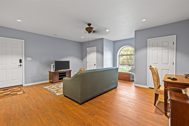 living room with ceiling fan and light hardwood / wood-style flooring