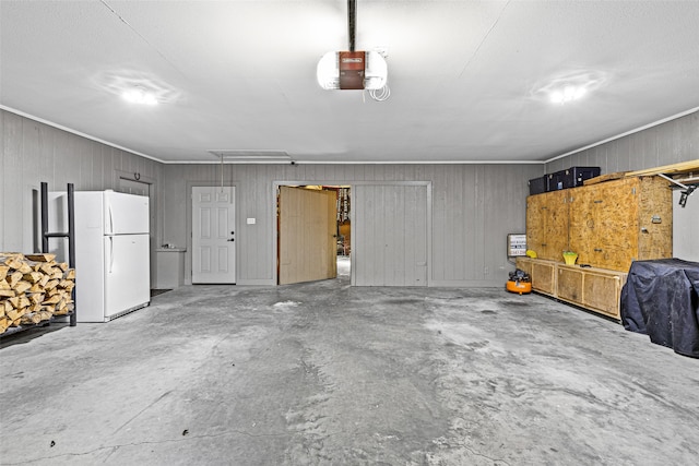 garage with white fridge and a garage door opener