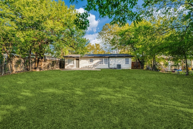 rear view of house featuring a patio, a yard, and central AC unit