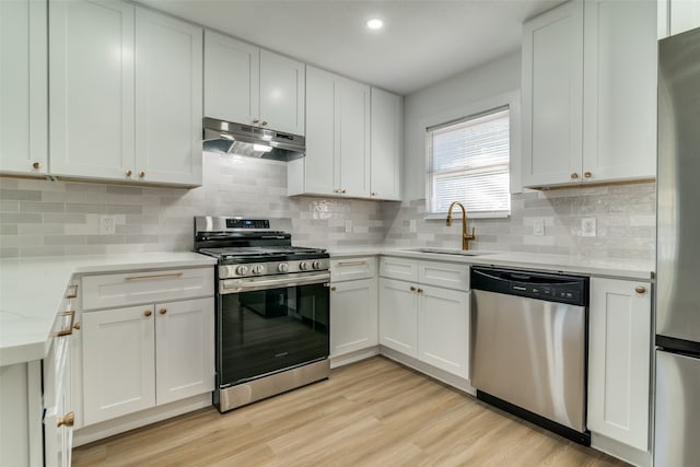 kitchen with appliances with stainless steel finishes, white cabinetry, and sink