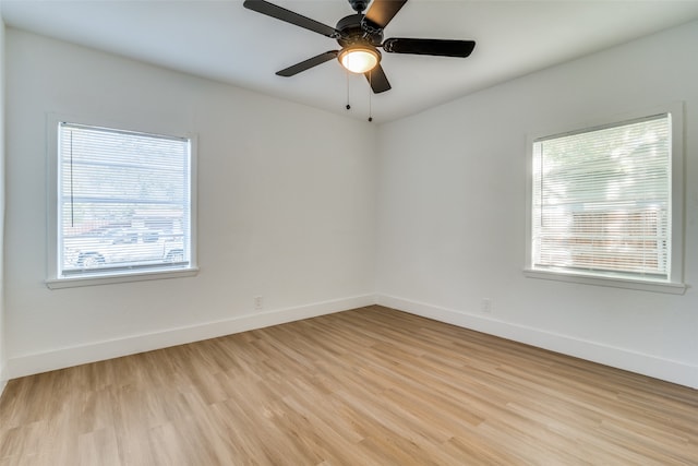 spare room with ceiling fan, a healthy amount of sunlight, and light wood-type flooring