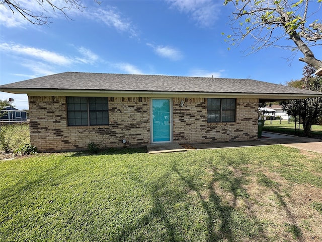 ranch-style home featuring a front lawn and a carport