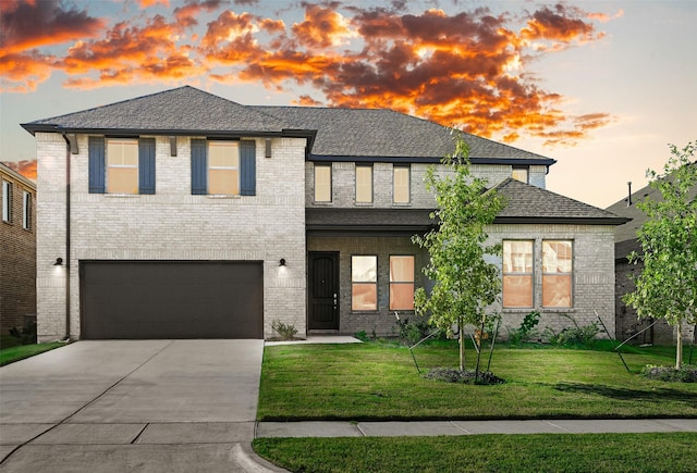 view of front of home featuring a lawn and a garage