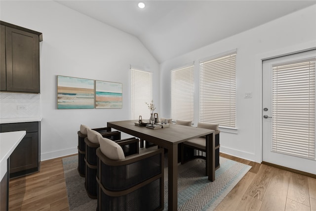 dining area featuring light hardwood / wood-style floors and lofted ceiling