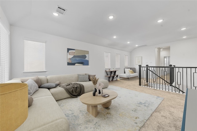 carpeted living room featuring a wealth of natural light and vaulted ceiling