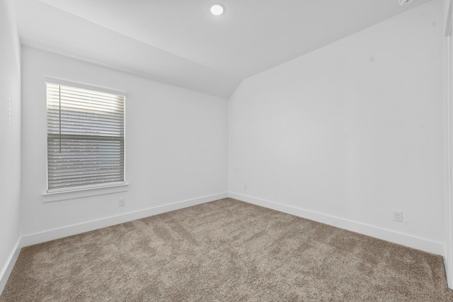 empty room with carpet and vaulted ceiling