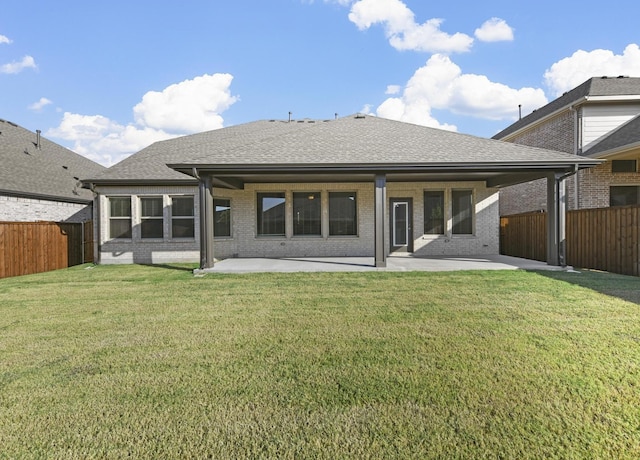 rear view of house featuring a lawn and a patio area