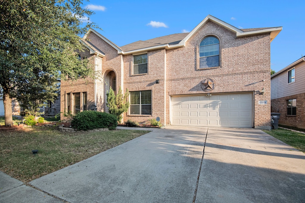 front facade featuring a garage and a front lawn