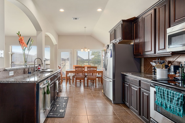 kitchen featuring dark brown cabinets, stainless steel appliances, lofted ceiling, and sink