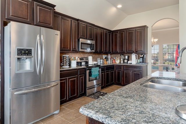 kitchen featuring decorative backsplash, appliances with stainless steel finishes, vaulted ceiling, light tile patterned flooring, and sink