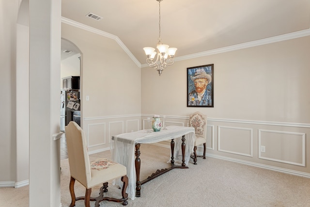 dining room featuring ornamental molding, a chandelier, and light colored carpet