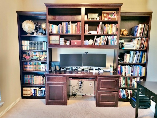 carpeted home office featuring built in desk