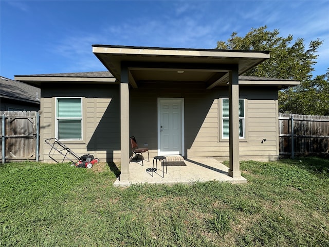 back of house with a patio and a yard