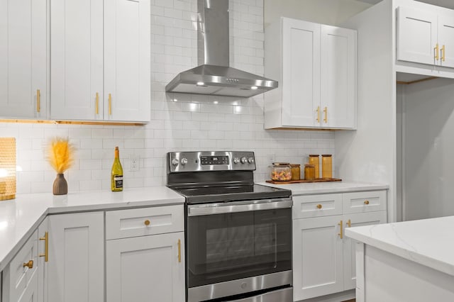 kitchen featuring white cabinets, wall chimney exhaust hood, stainless steel electric range oven, tasteful backsplash, and light stone counters