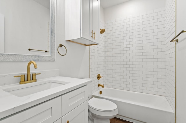 full bathroom featuring vanity, tiled shower / bath combo, and toilet