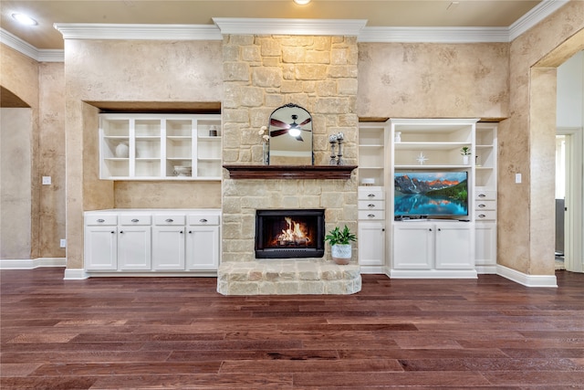 unfurnished living room featuring a stone fireplace, crown molding, ceiling fan, and dark hardwood / wood-style flooring