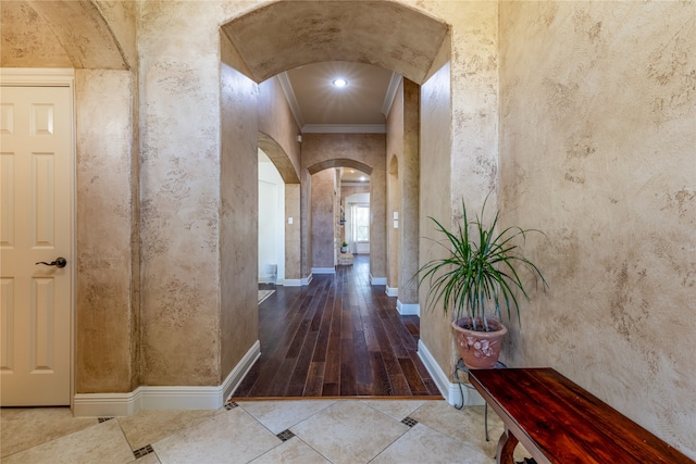 corridor with ornamental molding and hardwood / wood-style floors