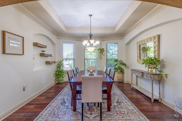 dining room with crown molding, a tray ceiling, and dark wood-type flooring