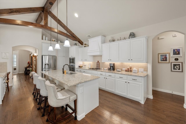 kitchen with white cabinetry, a kitchen island with sink, decorative light fixtures, and dark hardwood / wood-style flooring